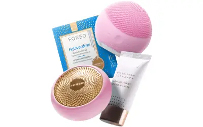 A pink and gold beauty set with a face mask, body lotion and soap.